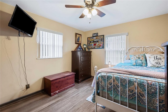 bedroom with ceiling fan, baseboards, and wood finished floors