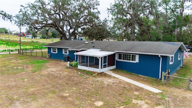 back of property featuring central AC unit, a sunroom, and fence