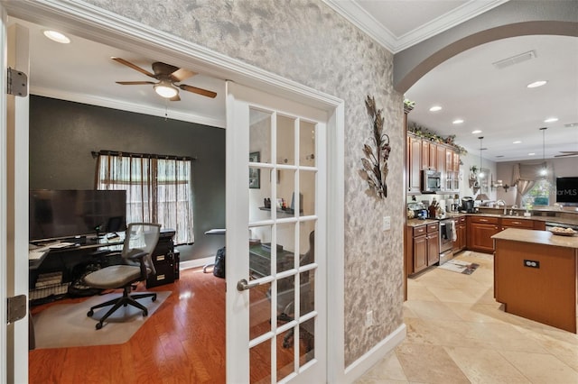 office featuring ceiling fan, crown molding, light hardwood / wood-style floors, and sink