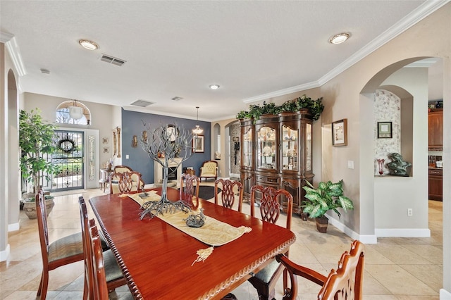 dining room with ornamental molding and light tile patterned floors