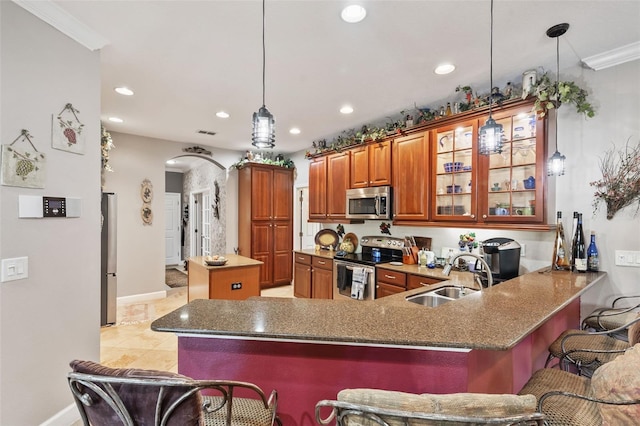 kitchen with sink, kitchen peninsula, a breakfast bar area, pendant lighting, and appliances with stainless steel finishes