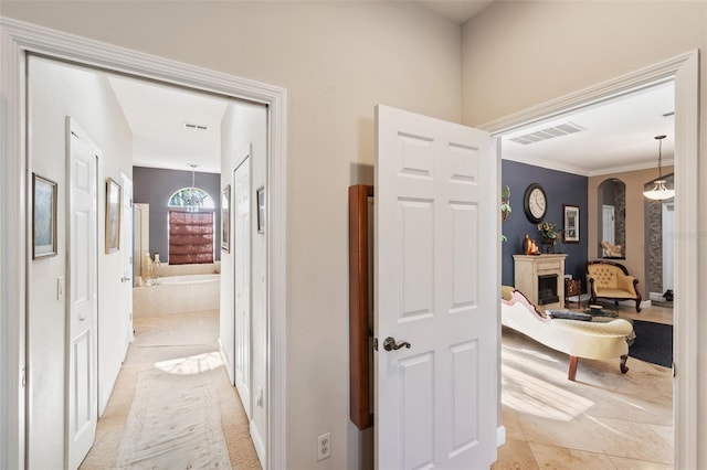 hallway featuring light tile patterned flooring and crown molding