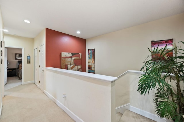 hall featuring light colored carpet