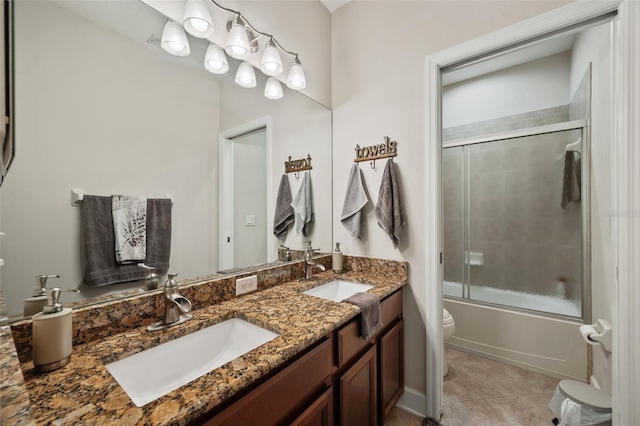 full bathroom featuring tile patterned flooring, bath / shower combo with glass door, vanity, and toilet