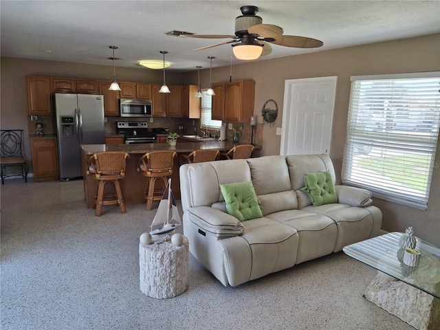 living room with ceiling fan and sink