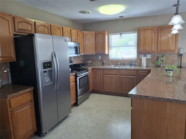 kitchen with tasteful backsplash, sink, hanging light fixtures, stainless steel appliances, and a textured ceiling