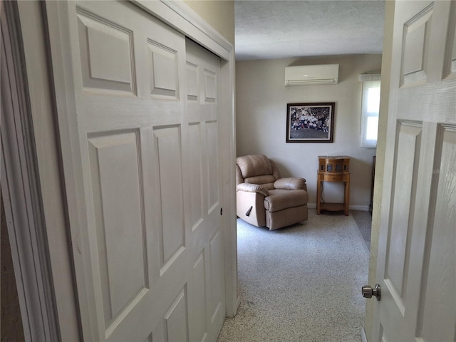 corridor featuring an AC wall unit and a textured ceiling