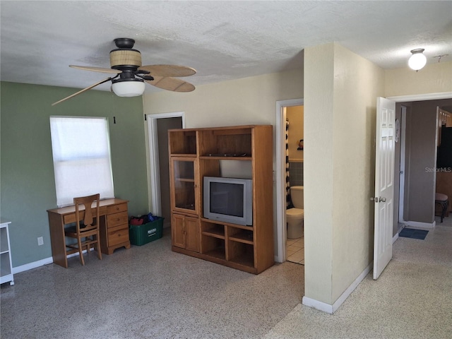 living room featuring ceiling fan and a textured ceiling