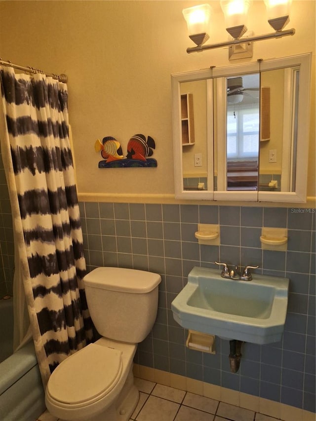 full bathroom with sink, tile walls, toilet, tile patterned floors, and shower / bath combo with shower curtain