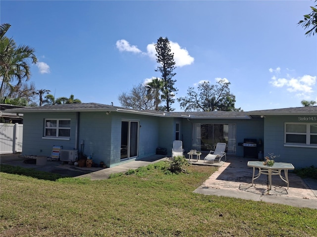 back of property with a yard and a patio area