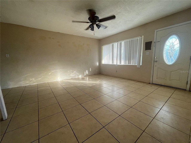 foyer featuring light tile patterned floors, a textured ceiling, and ceiling fan