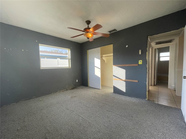 carpeted empty room featuring a textured ceiling and ceiling fan