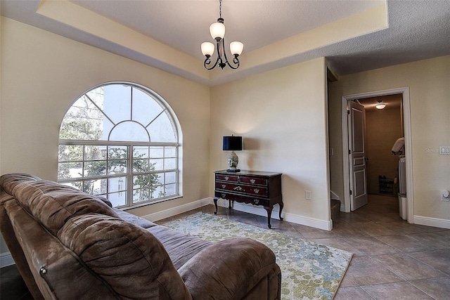 living room featuring a chandelier and a tray ceiling