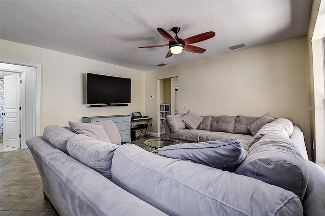 tiled living room with ceiling fan and a textured ceiling