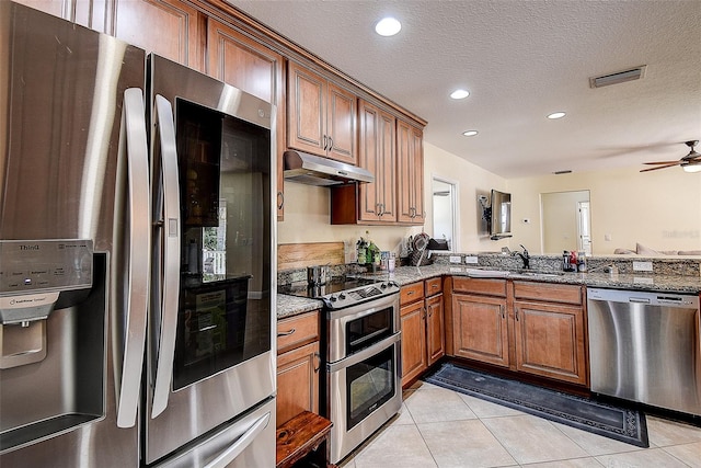 kitchen featuring ceiling fan, appliances with stainless steel finishes, light tile patterned flooring, a textured ceiling, and sink