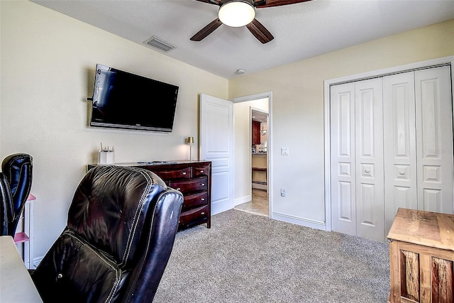 office space with light carpet, ceiling fan, and a baseboard heating unit