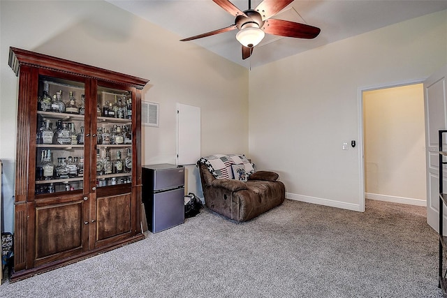 sitting room with ceiling fan and light colored carpet