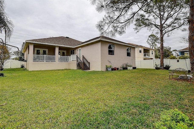 rear view of property featuring a yard