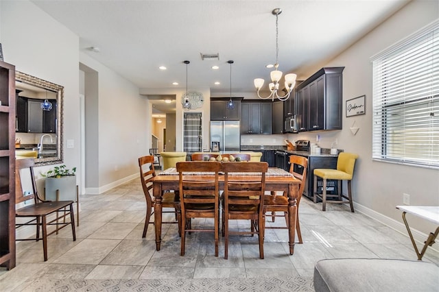 dining area with sink, light tile patterned flooring, and a chandelier