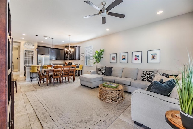 tiled living room featuring ceiling fan with notable chandelier