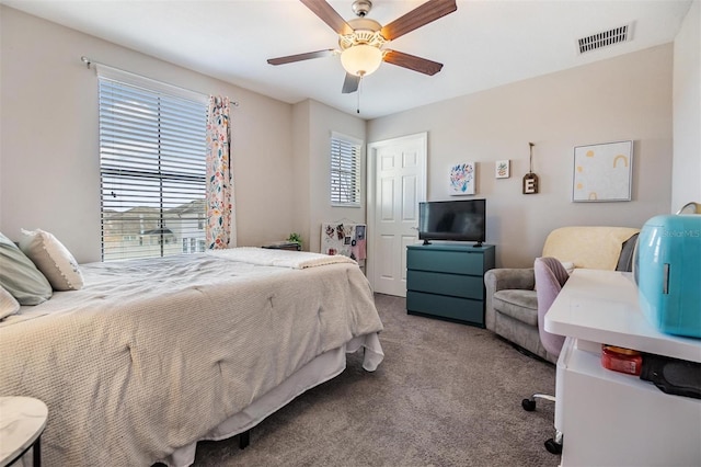 carpeted bedroom with ceiling fan and multiple windows