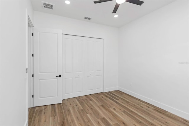 unfurnished bedroom featuring ceiling fan, a closet, and light hardwood / wood-style flooring