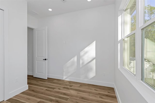 spare room with plenty of natural light and hardwood / wood-style floors