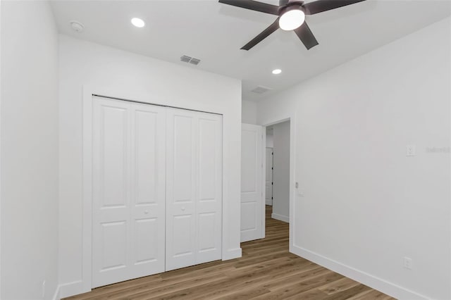 unfurnished bedroom featuring ceiling fan, a closet, and hardwood / wood-style floors