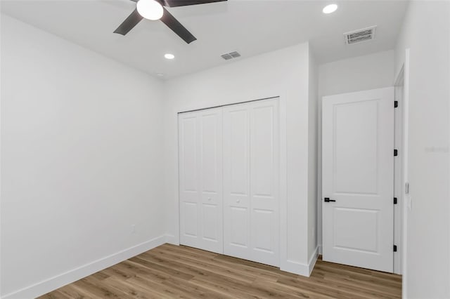 unfurnished bedroom featuring ceiling fan, hardwood / wood-style flooring, and a closet