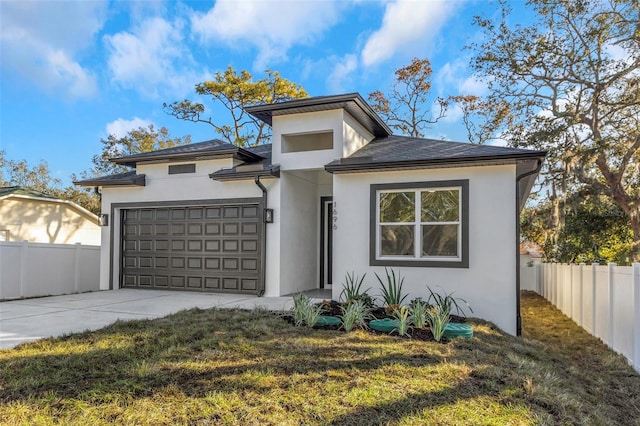 prairie-style home featuring a garage and a front lawn