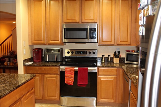 kitchen with stainless steel appliances and dark stone countertops