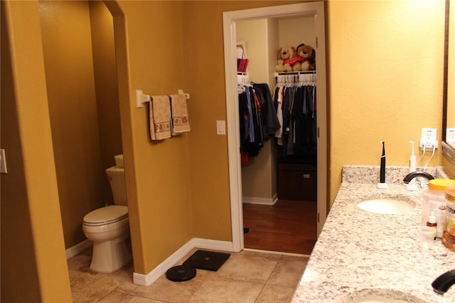 bathroom featuring tile patterned flooring, vanity, and toilet