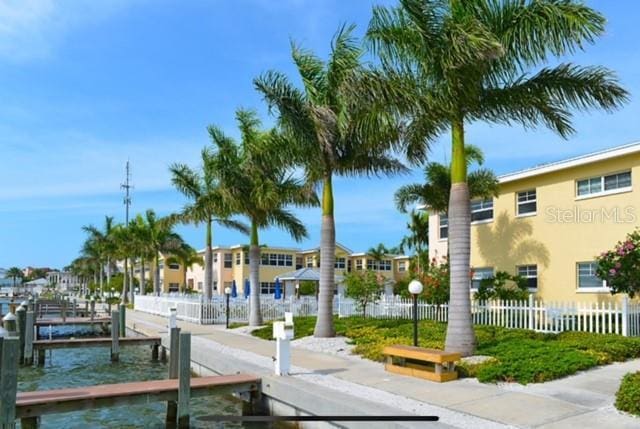 view of dock featuring a water view and fence