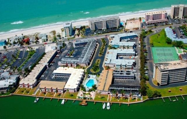 birds eye view of property with a water view and a beach view