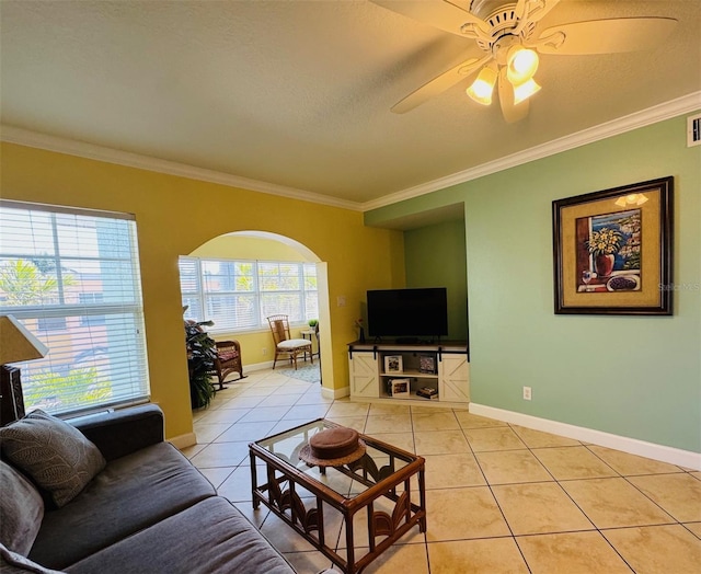 living area with arched walkways, light tile patterned flooring, baseboards, and crown molding