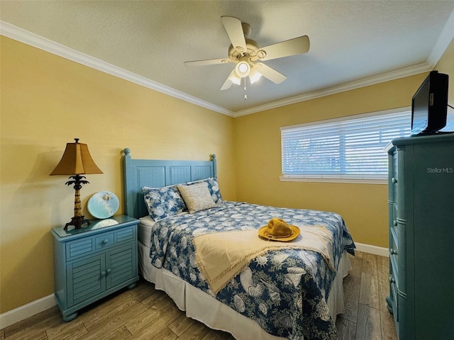 bedroom with ornamental molding, baseboards, and wood finished floors