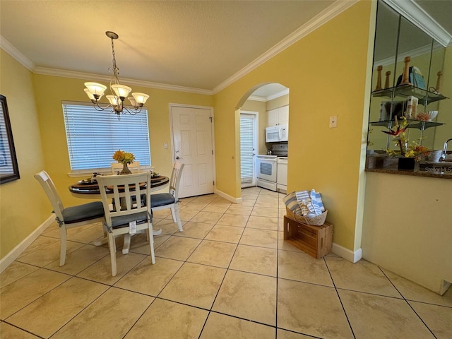 dining area with baseboards, arched walkways, an inviting chandelier, crown molding, and light tile patterned flooring