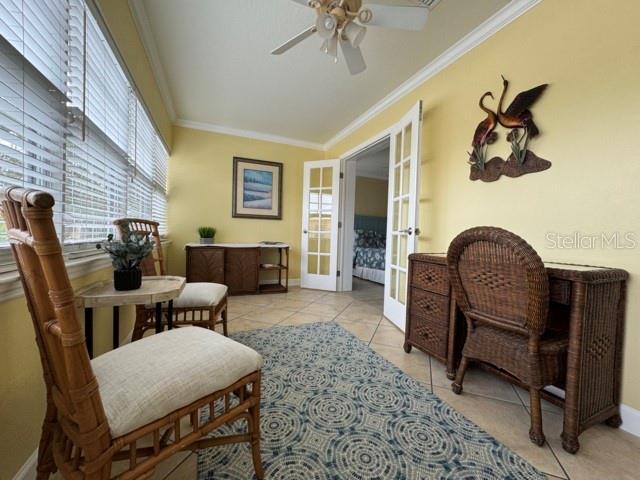 living area with plenty of natural light, french doors, and crown molding