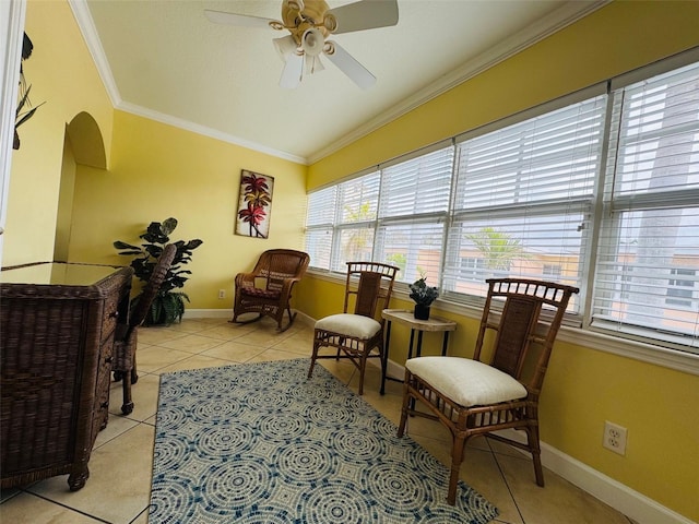 living area featuring light tile patterned floors, ceiling fan, baseboards, vaulted ceiling, and crown molding