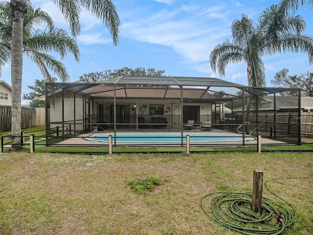 view of swimming pool featuring glass enclosure and a yard