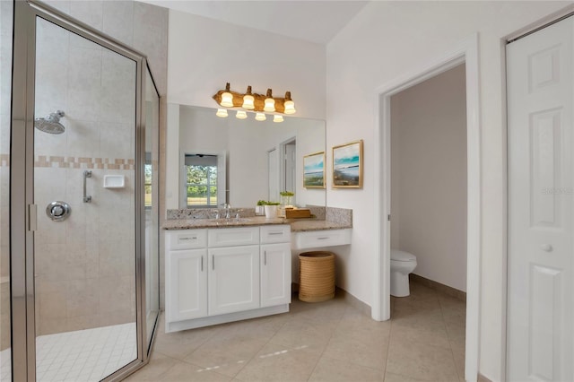 bathroom with toilet, vanity, tile patterned flooring, and a shower with door