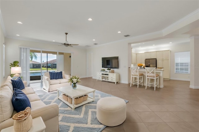 living room with light tile patterned floors, ornamental molding, and ceiling fan