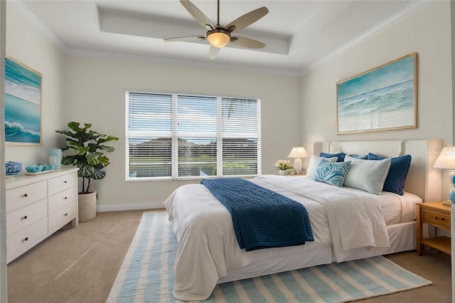 carpeted bedroom with a raised ceiling, ornamental molding, and ceiling fan