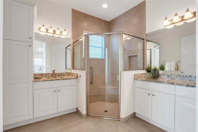 bathroom with walk in shower, vanity, and tile patterned flooring