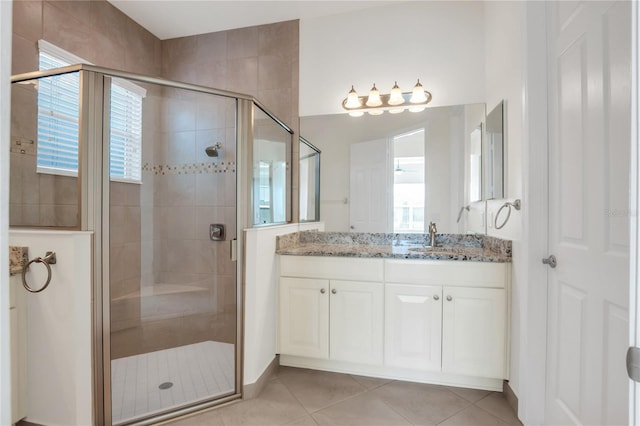 bathroom featuring walk in shower, vanity, and tile patterned flooring