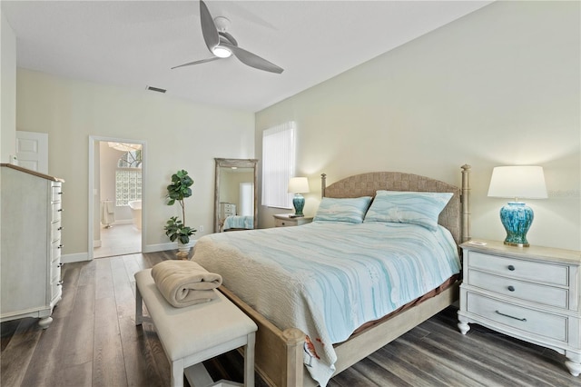 bedroom with ensuite bath, dark wood-type flooring, ceiling fan, and multiple windows