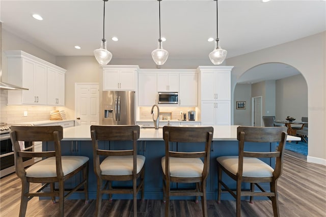 kitchen featuring decorative light fixtures, appliances with stainless steel finishes, decorative backsplash, and white cabinetry