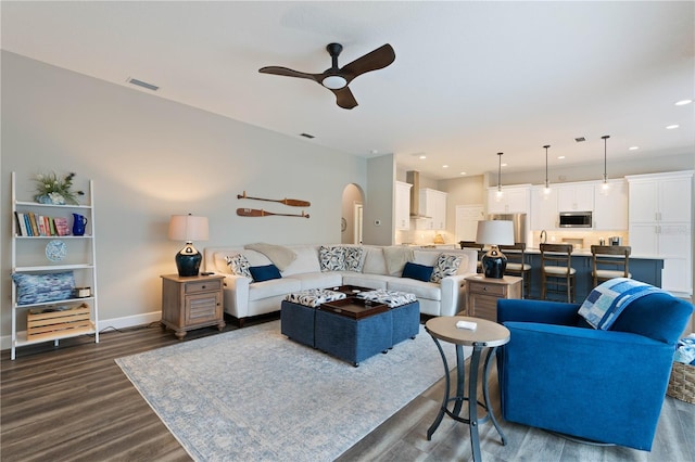 living room with dark hardwood / wood-style flooring and ceiling fan