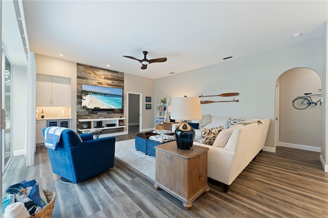 living room featuring ceiling fan and dark hardwood / wood-style floors