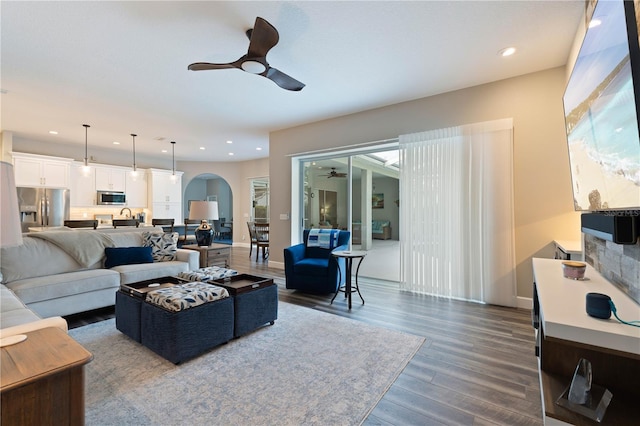 living room featuring dark wood-type flooring and ceiling fan